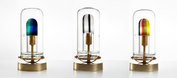The Seneca Series Pendant is an exploration of modern glass blowing, blending together traditional techniques with a newly discovered borosilicate glass palettes. Rods of colored glass are stacked between two pieces of clear glass tubing. The pieces are then melted from one side to the other, creating a cohesive colored glass tube. A master glassblower then creates a colored glass chamber inside of a larger piece of clear tubing. An LED bulb illuminates the colored glass, providing a one-of-a-kind, candle-like glow.